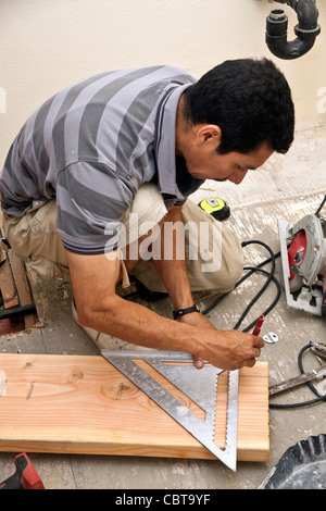 Hispanic man from Mexico working his own construction business in the USA replaces shower. MR © Myrleen Pearson Stock Photo