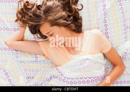 Caucasian teenager sleeping in bed Stock Photo