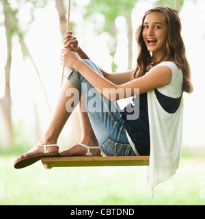 Caucasian girl sitting on swing Stock Photo