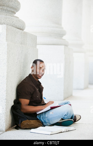 Black college student doing homework outdoor Stock Photo