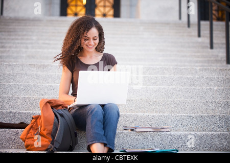 Caucasian college student using laptop outdoors Stock Photo