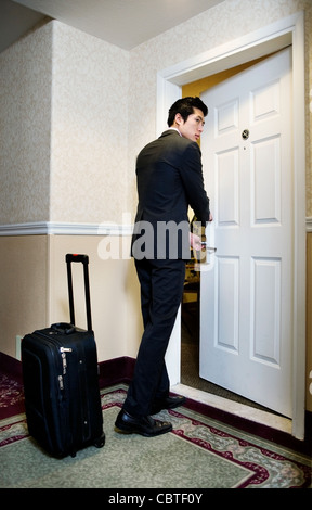 Asian businessman entering hotel room Stock Photo