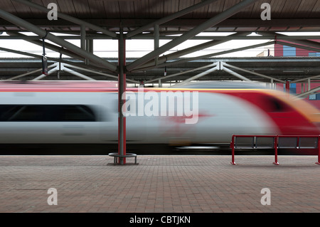 Virgin Pendolino train passing through Rugby railway station at high speed, Warwickshire, UK Stock Photo