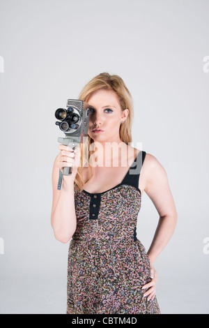 Pretty girl looking through a vintage movie camera Stock Photo