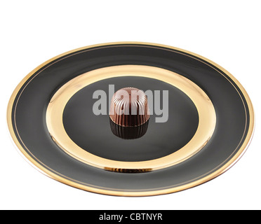 chocolate candy on a black plate on white background Stock Photo