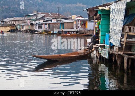 A Kashmiri man sits at his shop in the floating market of Dal Lake Stock Photo