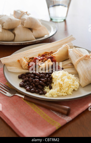 Tamales, beans and rice on plate Stock Photo