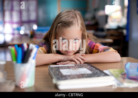 Bored Caucasian girl sitting in classroom Stock Photo