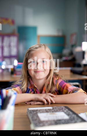 a girl sitting at a desk in a classroom Stock Photo - Alamy