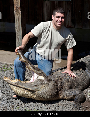 A hunter shows off a 12-foot alligator he caught during the 3-week long alligator hunting season September 27, 2009. About 300 alligators are taken during the short season out of an estimated 150,000 alligators in SC waters. Stock Photo