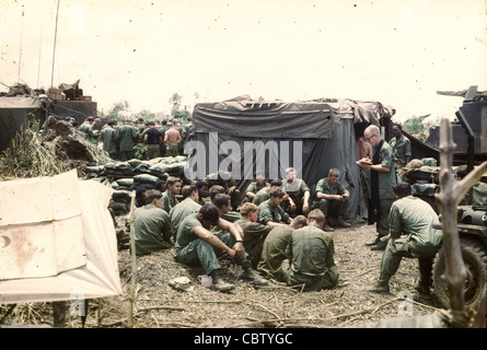 11th Armored Cavalry Regiment chaplain ministers to a group of US GIs in a camp near Quan Loi during 1969. LTC Trobrough's photos of the 11th ACR and elements of the 1st Cavalry Division - including helicopters of the 1st Squadrond, 9th Cavalry at Quan Loi and the surrounding area of operations in III Corps in Vietnam. Trobough was a chaplain. Stock Photo