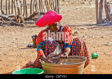 Herero woman washing clothes, Damaraland, Namibia Stock Photo