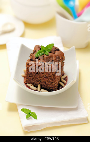 Brownie with cherry jam and pine nuts. Recipe available. Stock Photo