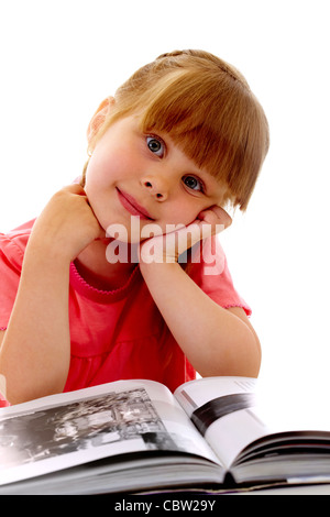Portrait of cute girl looking at camera while reading interesting book Stock Photo