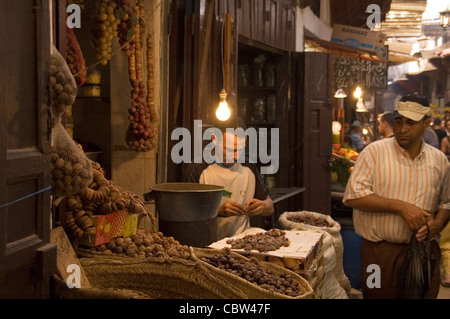 Man selling dates from his stall in the medina of Fez in northern Morocco Stock Photo