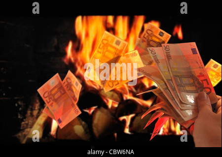 Burning European money by throwing euro bank notes in flames of fireplace to symbolize recession and crisis in the Europe zone