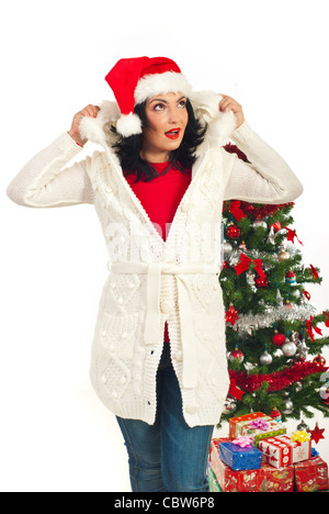 Surprised Santa helper woman in winter clothes looking up and holding her fur hood against white background Stock Photo