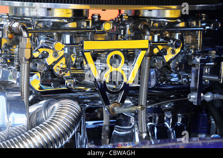 Dual Chromed carburetors connected with V8 symbol linkage. Stock Photo