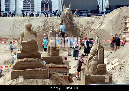 Members of the public are dwarfed by the giant sand sculptures at Black Rock Brighton - sand festival Stock Photo