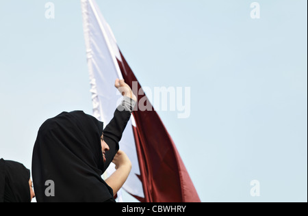 Happy qatari women wave as the Emir of Qatar passes them during the Qatar National Day parade. Stock Photo