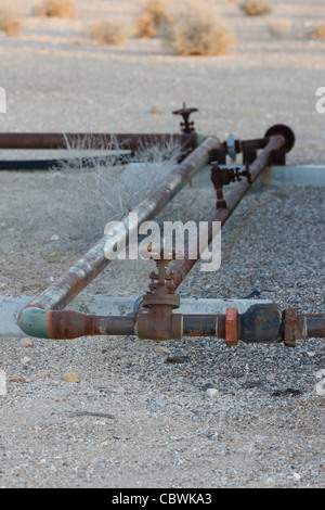 Close up of oil transfer pipes leading to and from and oil well head on an oil well Stock Photo