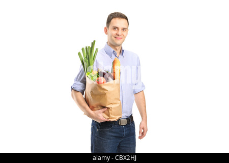 A man holding a shopping bag full of food Stock Photo