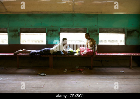 Two Passengers inside empty train car in Yangon, Myanmar Stock Photo