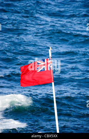 A Merchant Navy Red Ensign flag seen against the blue sea on the English Channel from a ferry Stock Photo