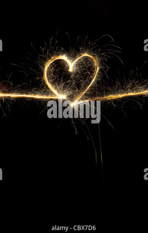 Heart shape made with sparkler at night. Stock Photo