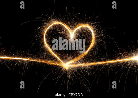 Heart shape made with sparkler at night. Stock Photo