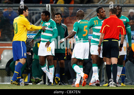 Kaka of Brazil (10) pushes Kader Keita of Ivory Coast (18) as Didier Drogba argues with referee Stephane Lannoy - '10 World Cup. Stock Photo