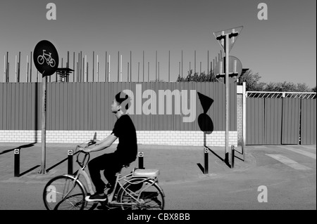 Beijing, Maizidian. Man on a bike passing a construction site. Stock Photo