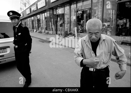 Fan WuBiao, a security guard, and Mr. Li BaoTian, a night guard at a depot for building materials. Stock Photo