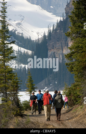 People walking on trail beside Lake Louise, Banff, Alberta, Canada Stock Photo