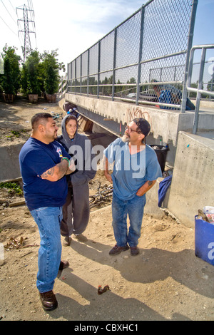 An official of the charitable outreach program Vet Hunters greets a homeless military veteran living under a California bridge. Stock Photo