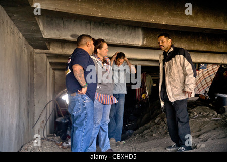 An official of the charitable outreach program Vet Hunters greets a homeless military veteran living under a California bridge. Stock Photo