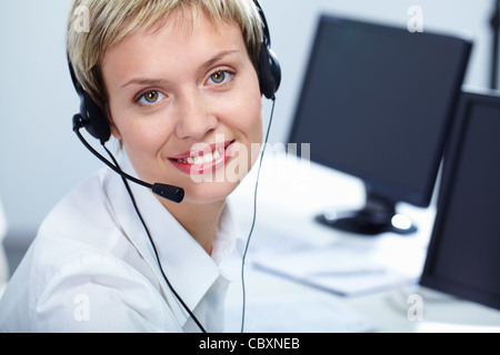 Portrait of beautiful woman with headset looking at camera and smiling Stock Photo