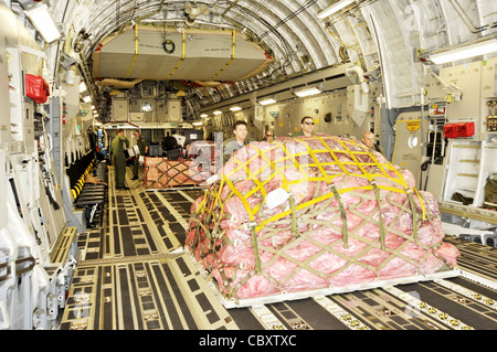 Airmen from the multinational Heavy Airlift Wing based at Papa Air Base, Hungary, unload a C-17 Globemaster III at Baghdad International Airport, Iraq. The airlift into Iraq was a first by the wing and facilitated the deployment for members of the NATO Training Mission-Iraq. The wing operates three C-17s and includes NATO member nations Bulgaria, Estonia, Hungary, Lithuania, the Netherlands, Norway, Poland, Romania, Slovenia and the U.S., as well as Partnership for Peace nations Finland and Sweden Stock Photo