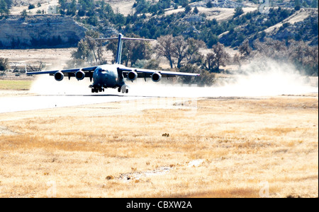 A C-17 Globemaster III from McChord Air Force Base, Wash., lands at the Wyoming National Guard's Guernsey Army Airfield in Guernsey, Wyo., Oct. 17, 2009, during the official opening of the updated airstrip now capable of handling the massive cargo aircraft. The airstrip is now able to park up to 23 fixed-wing aircraft, including three C-17s. In addition to the civilian-military airstrip, Camp Guernsey also boasts nearly 70,000 acres of terrain and supports approximately 65 square miles of restricted air space up to 30,000 feet. Stock Photo