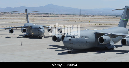 Two C-17 Globemasters taxi in on the Nellis Air Force Base, Nev., flightline May 20 as part of the Mobility Air Forces Exercise. The 57th Weapons Squadron provides advanced tactical training to C-17 Globemaster aircrew selected to attend the United States Weapons School course here. The six month graduate-level course culminates in a massive airlift mission, called the Mobility Air Forces Exercise. More than 30 airlift assets and hundreds of support personnel from installations across the Air Force participate in the biannual training exercise. Stock Photo