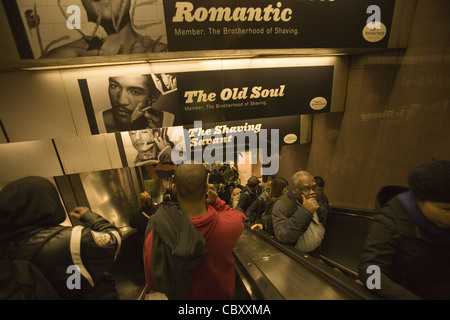 Commuters ride escalators between Grand Central Terminal and the lower level subway station in Manhattan Stock Photo