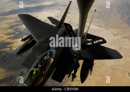 An F-15E Strike Eagle aircraft receives fuel from a KC-135 Stratotanker during a mission over Afghanistan. The F-15E provides close-air support and armed aerial overwatch to deter enemy activities. Stock Photo