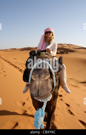 A woman riding a camel in Erg Chebbi, Sahara, Morocco