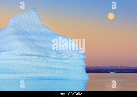Iceberg at Sunset and Moonrise at Hall Bredning, Scoresbysund, Greenland Stock Photo