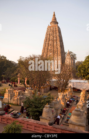 India, Bihar, Bodhgaya, Mahabodhi Temple, 6th century Buddhist temple where Buddha attained enlightenment, pilgrims prostrating Stock Photo