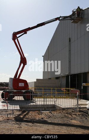 Man working in cherry picker on a new industrial unit Stock Photo