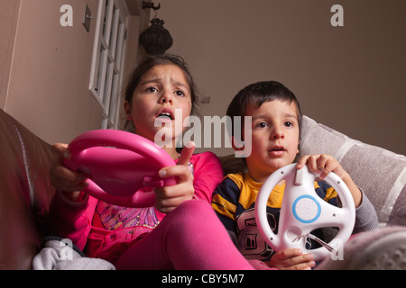 Siblings playing computer game at home Stock Photo