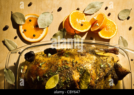 Baked chicken with orange fruit, dried plums and herbs Stock Photo