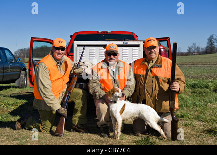 Three Upland Bird Hunters Posing Behind Truck with Shotguns, Quail and English Setter Stock Photo