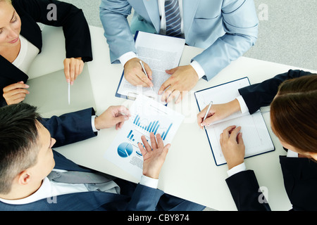 Image of business group discussing business documents at meeting Stock Photo